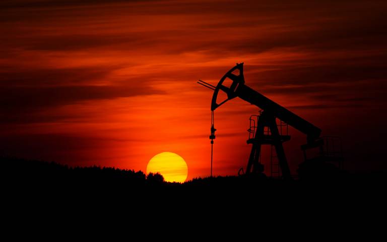 Pump-jack mining crude oil and sunset