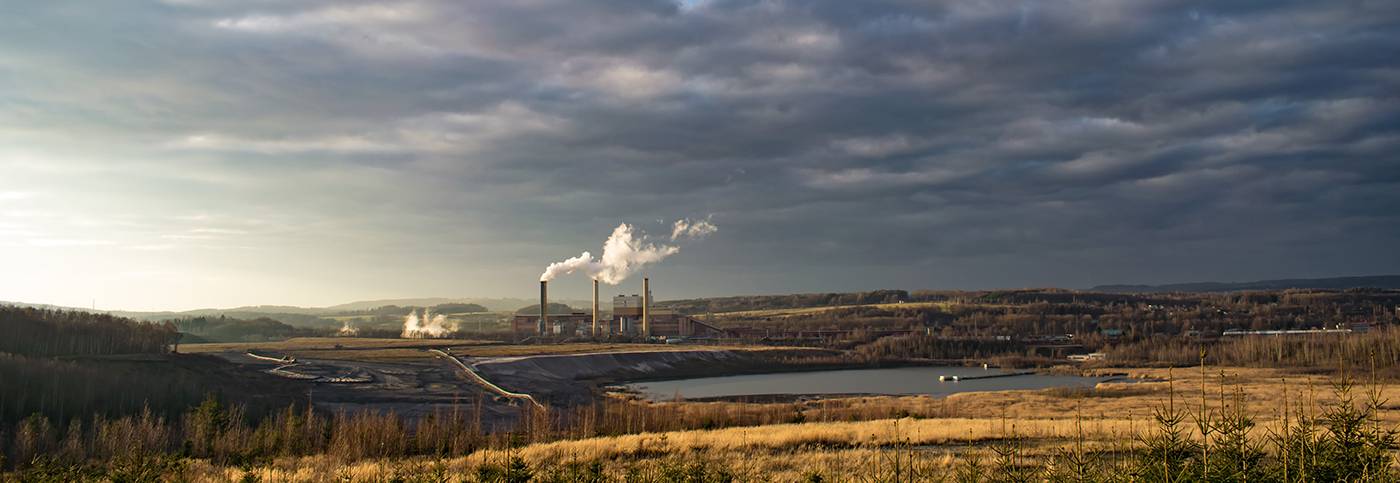 Rural landscape with power station blowing thick smoke in the background