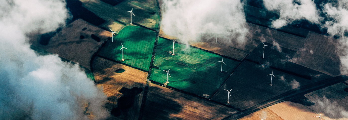 Aerial view of wind turbines through clouds