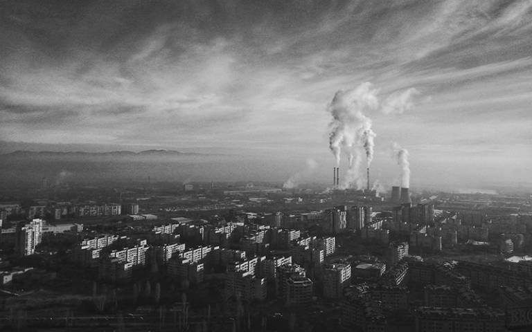 Black and white aerial photo over Sofia, Bulgaria, in which Sofia Power Plant can be seen in the distance.