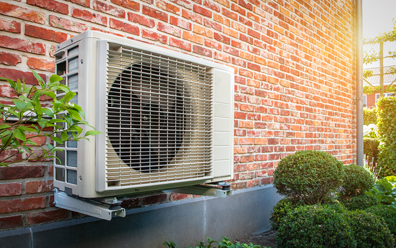 Photo of a heat pump on the side of a building