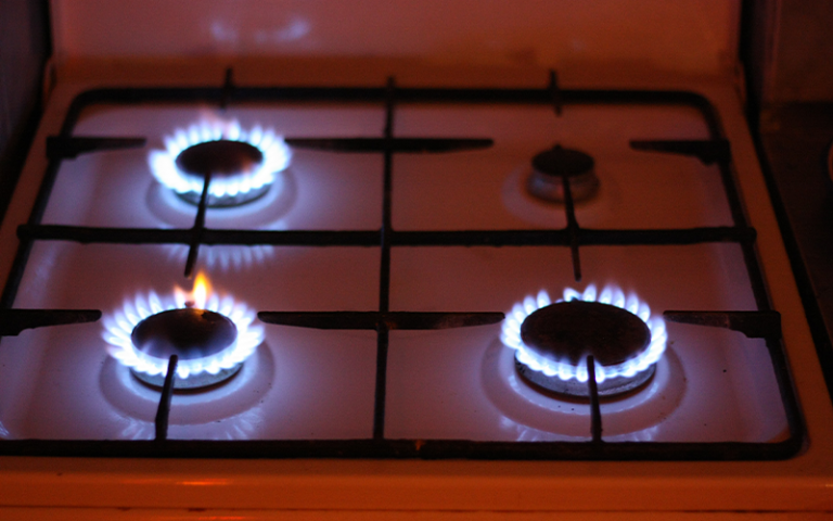 Photo of a stove with three out of four gas rings lit