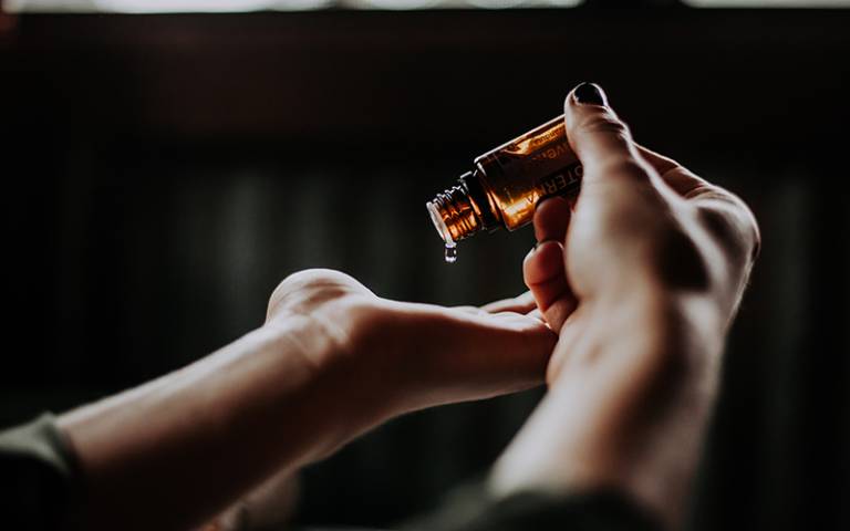 Person applying an essential oil to their hand