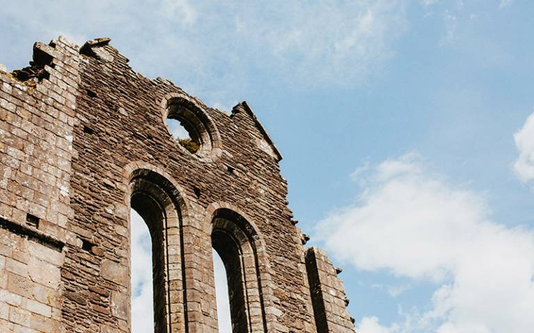 Photo of a ruined brick church with a blue sky in the background