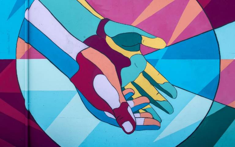 Photo of a painted mural showing a pair of colourful hands in Newberg, Oregon.