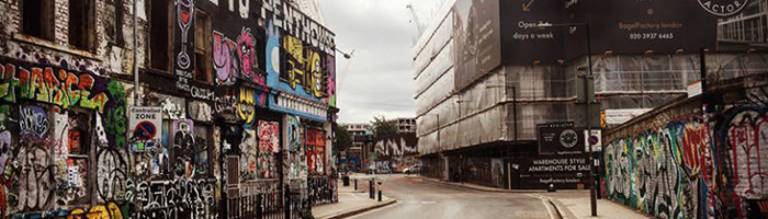 A photo of a real estate development Hackney Wick, London, next to a graffitied building
