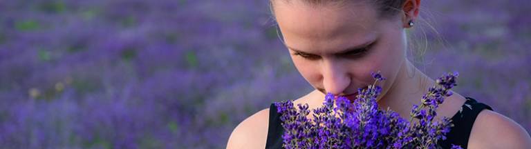 A photo of a woman smelling lavender 