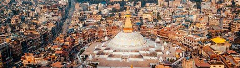 Photo of Stupa Bodhnath surrounded by the buildings of Kathmandu, Nepal