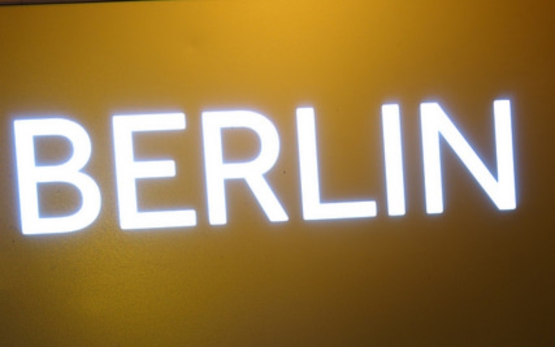 The word Berlin in light up letters on a yellow background