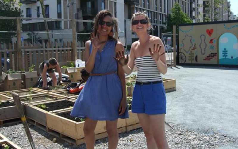 Two women pose in a community garden