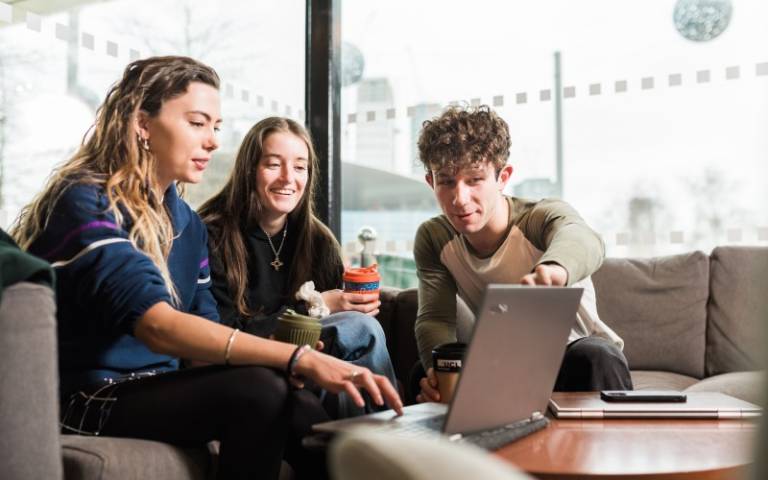 Three students sitting at a laptop