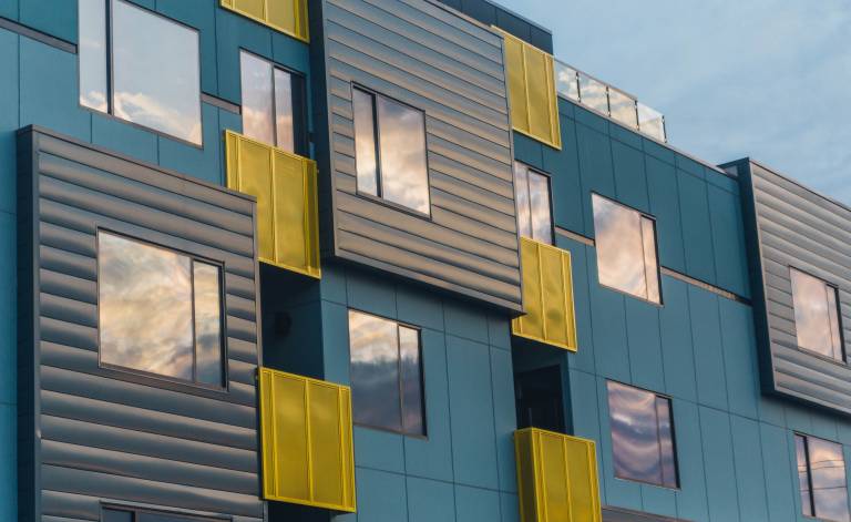 A modern building with blue and yellow cladding