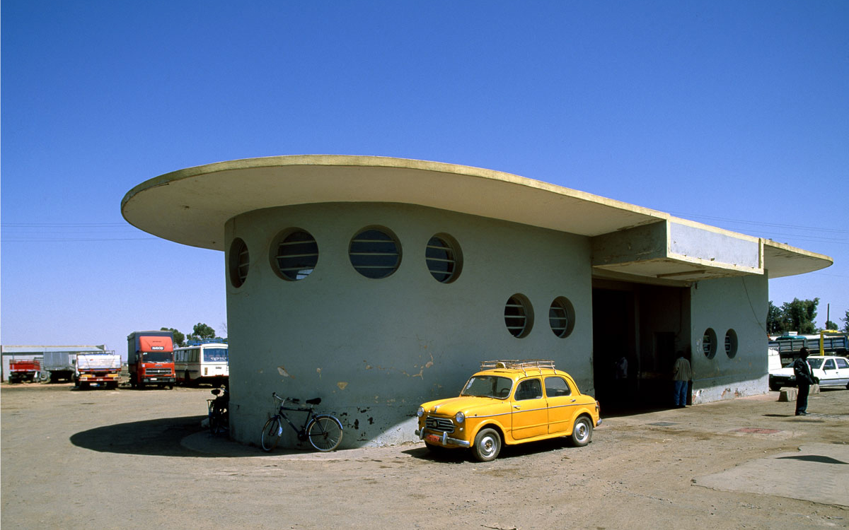 yellow car with derelict modernist service station