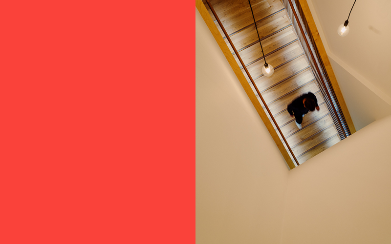 Split image of the colour red and a image of a staircase from above showing a person walking down