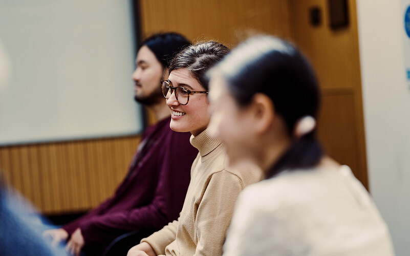 young woman smiles in seminar room