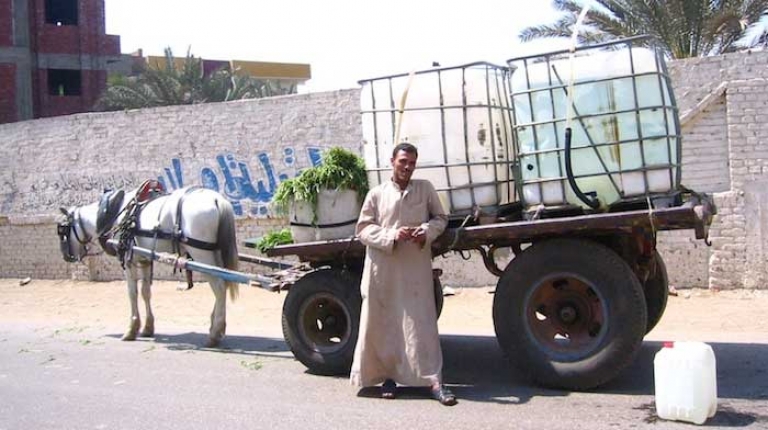 A man stands in front of a truck