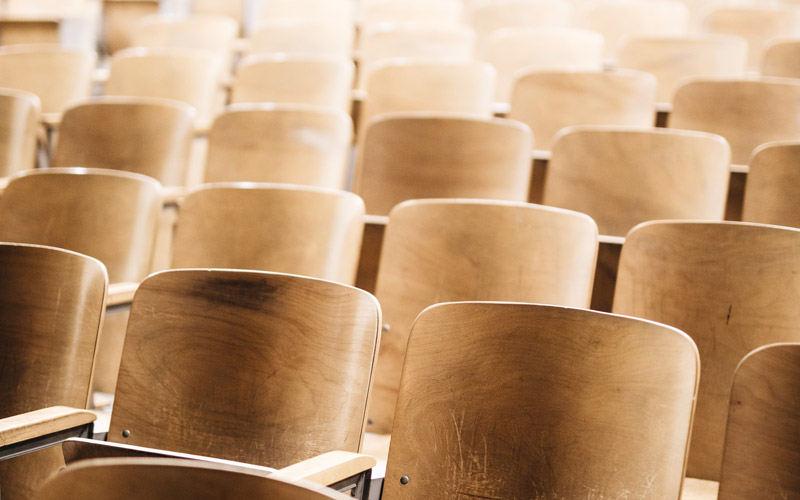 Rows of wooden seating in a lecture theatre