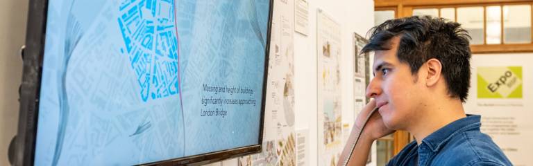 Photo of a student engaging with a planning presentation on a digital display