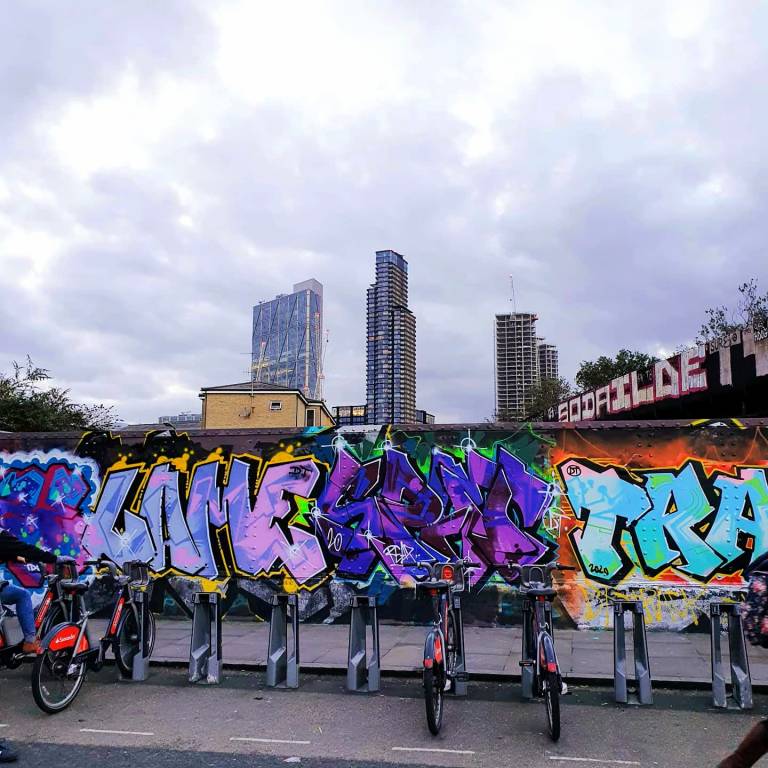 Boris bike racks and grafitti on a bridge in London