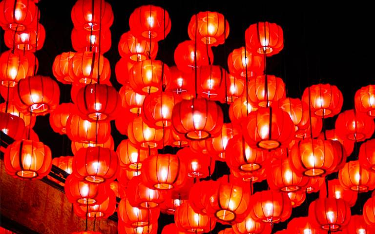 A cluster of red Chinese lanterns hanging from wires above 