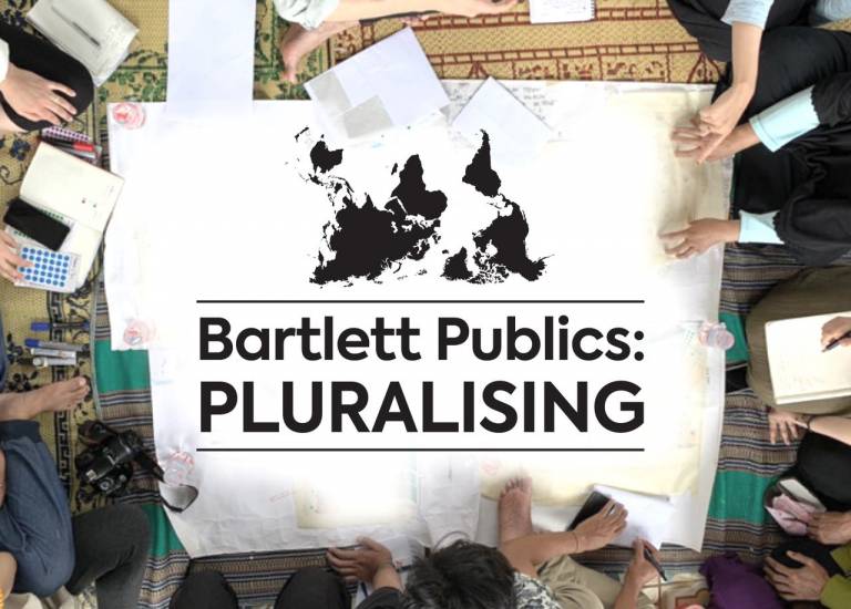 Overhead shot of people crowded around a desk with a large poster with a map of the world and the text Bartlett Publics: Pluralising