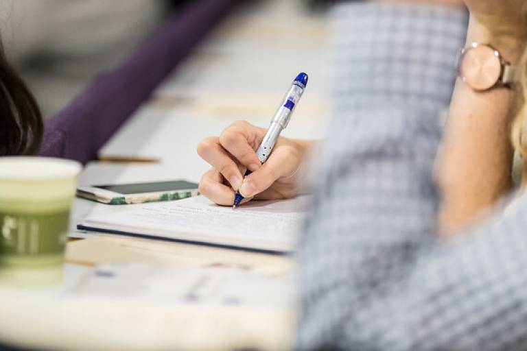 A PhD student at University College London takes notes during a group writing session.