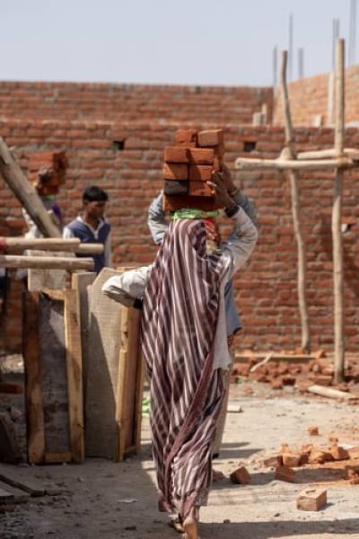 Lady carrying bricks on head