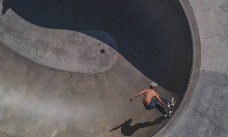 A skateboarder on a skate ramp, photograph taken from above