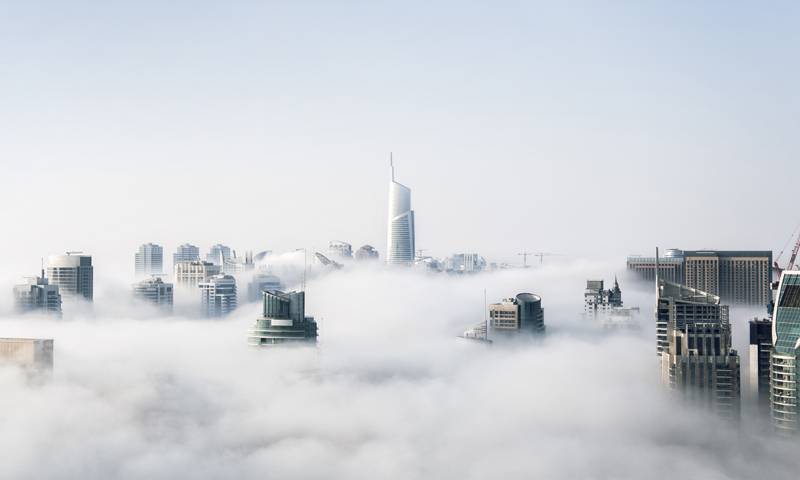 Skyscrapers poke through thick white clouds