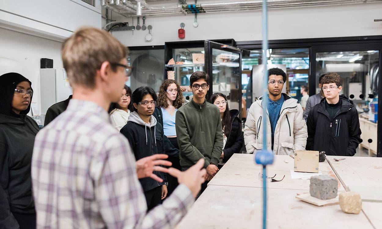 lecturer shows students around workshop space