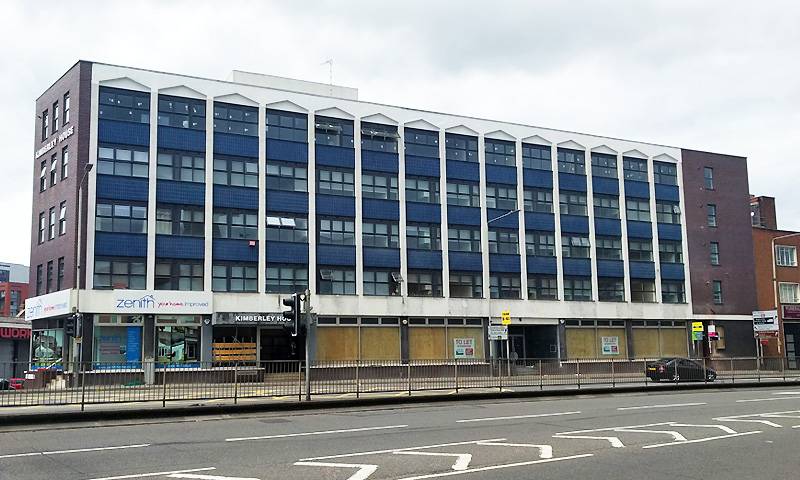 A run-down office block that is boarded up and ready to be renovated into flats
