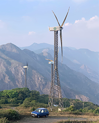 Wind turbine at the top of a mountain with a blue car