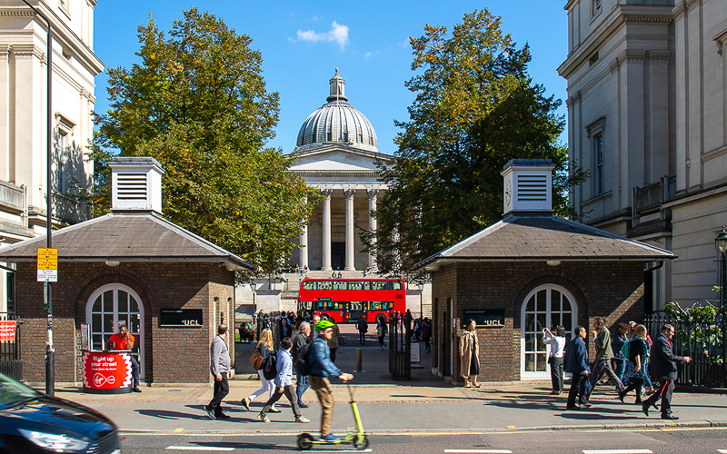 red bus in front of UCL Portico