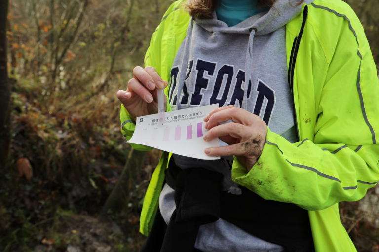 Citizen scientist collecting data on river water quality