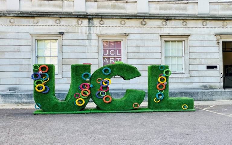 The UCL logo in the main quad in bright green letters with colourful circles decorating the letters.
