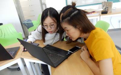 two_female_students_with_laptop