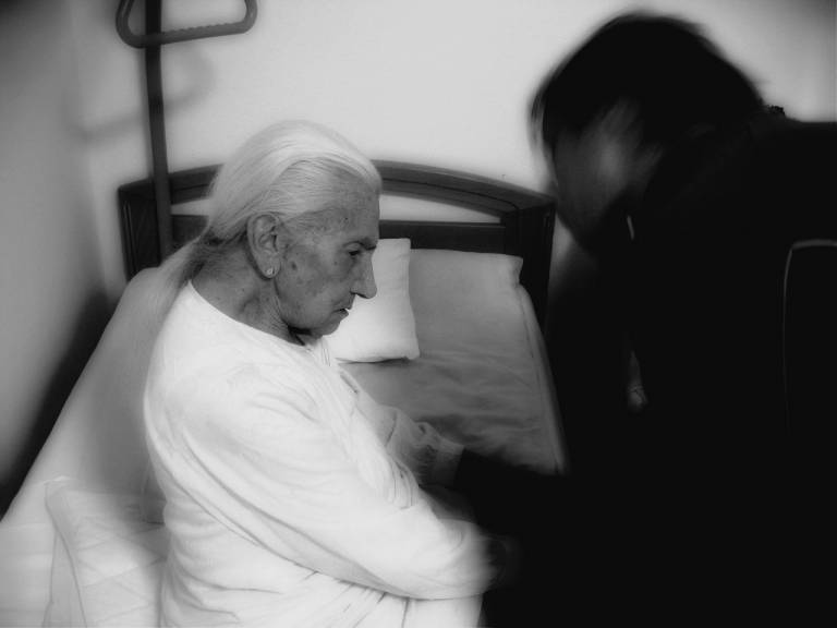 Older woman with dementia being attended to by a doctor 