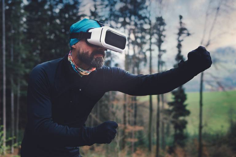 A man outdoors wearing a virtual reality headset