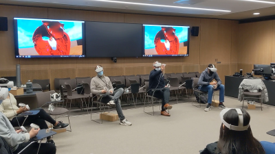 Professor Cook (arm raised), leading a lecture using the Oculus headsets, January 2022. Courtesy of Endrit Pajaziti