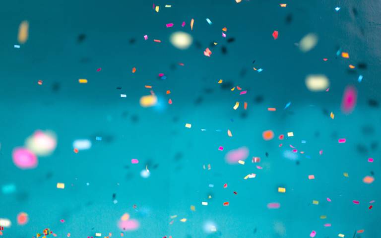 Confetti in front of a blue background.