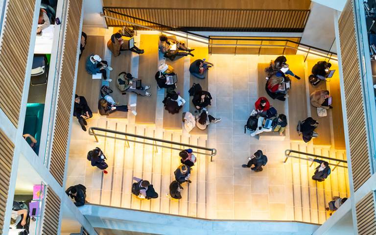 A birds-eye view image of students sat on steps within University College London's Student Centre, Main Quad.