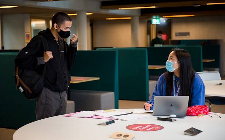 two students chatting, wearing masks