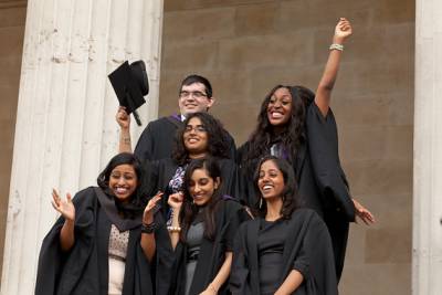 A group of students celebrating graduation in the Quad
