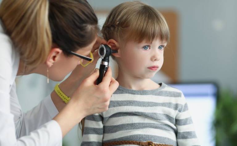 Girl having ear checked by doctor