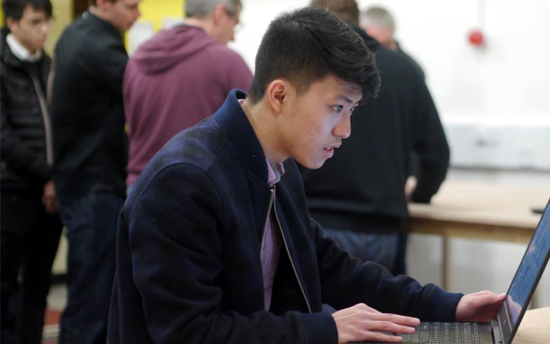 A young student using his laptop at a seminar
