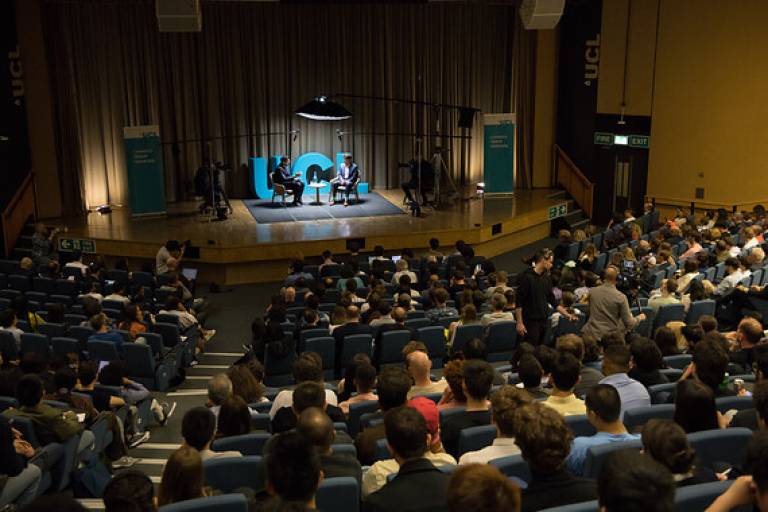 Image from UCL AI event. Two presenters are having a conversation on stage