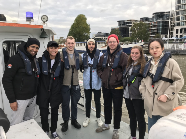 Students on board a boat wearing life jackets. 