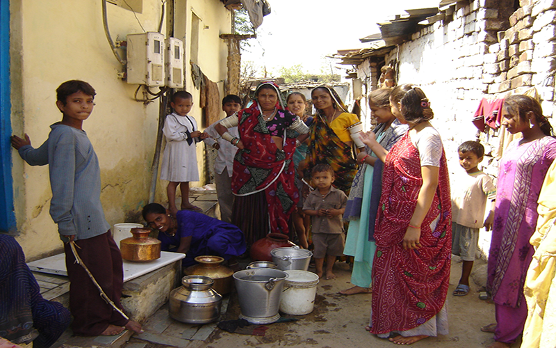 Women and children collecting water from a communal tap in India 