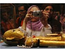 woman taking photo of archaeological artefact 