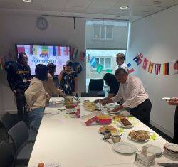 Photo of staff helping themselves to international food dishes.
